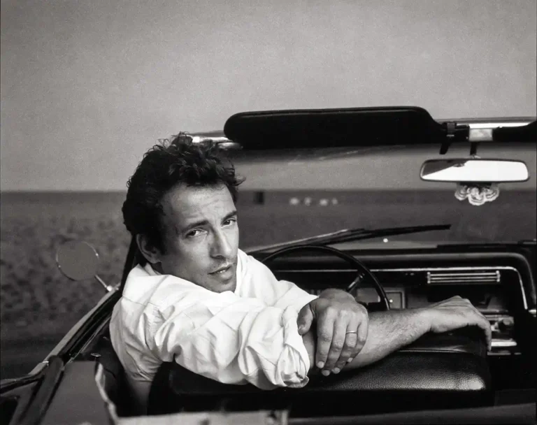 Bruce Springsteen music poster featuring a black and white portrait of the star leaning out of a vintage convertible car.