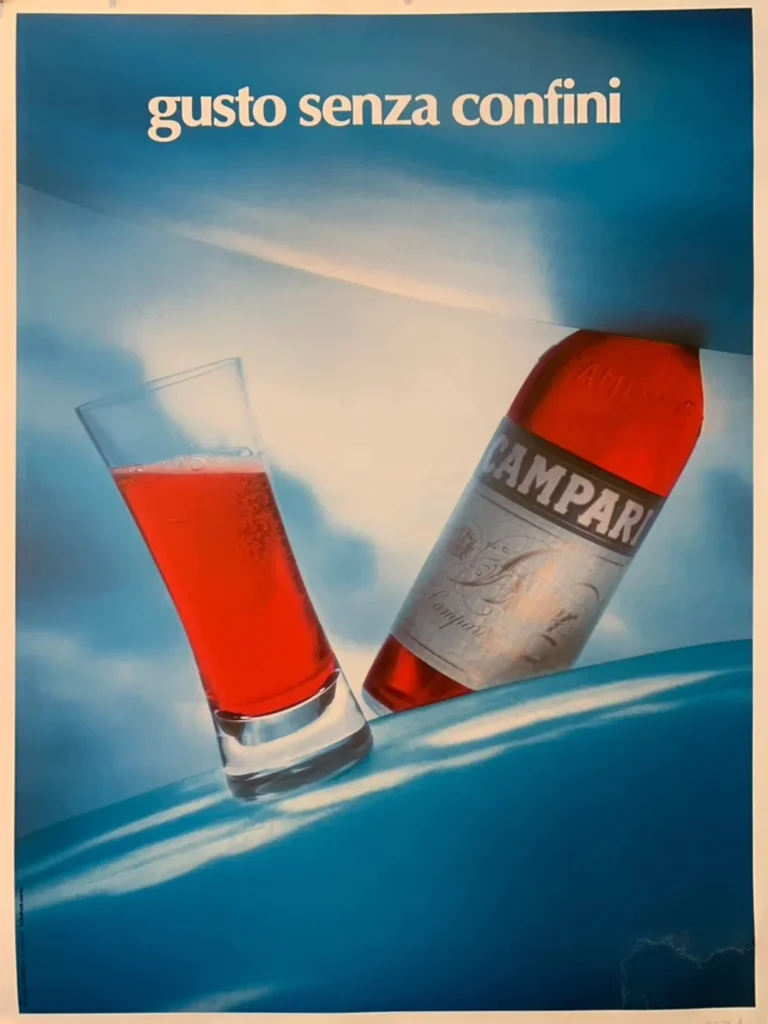Campari Gusto Senza Confini Vintage — vibrant red Campari bottle and matching cocktail glass rest against a