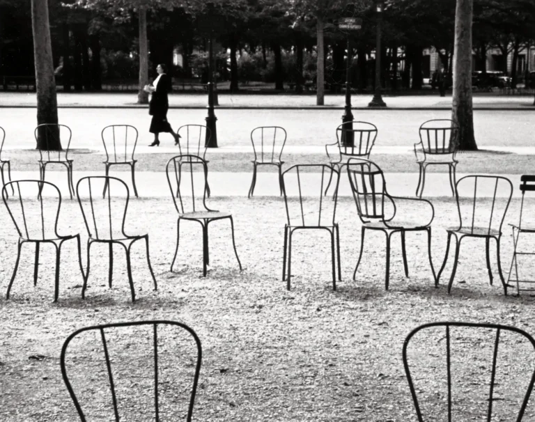 André Kertész fine art photography poster featuring scattered metal park chairs in a black and white Parisian street scene.