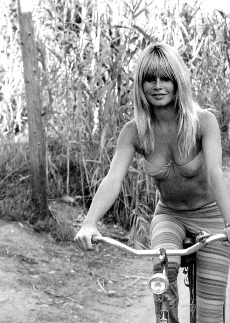 Brigitte Bardot Celebrity poster featuring her smiling on a bicycle in black and white photography.