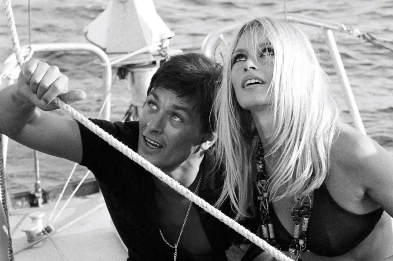 Brigitte Bardot & Alain Delon Celebrity poster featuring the iconic duo looking up on a sailboat in black & white.