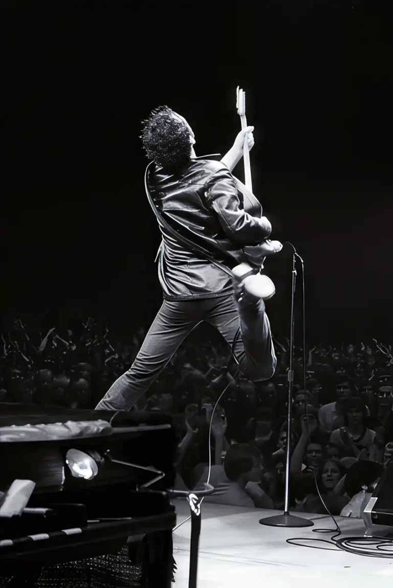 Bruce Springsteen Music poster featuring him mid-air, jumping with his guitar on stage in black and white.