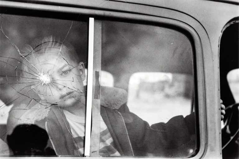 Elliott Erwitt art photography poster featuring a black and white image of a child looking intensely through a shattered car window.