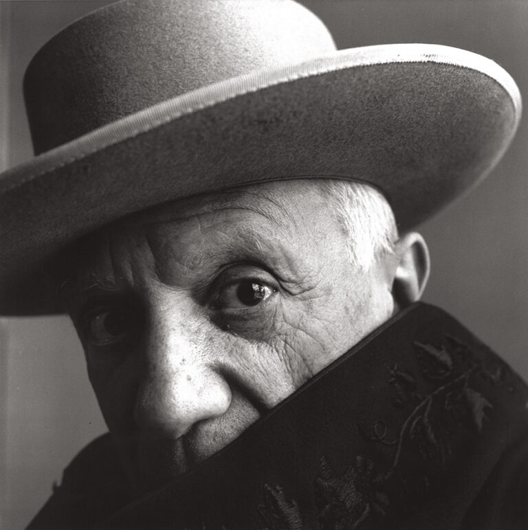 Pablo Picasso Art poster featuring the intense 1957 black and white portrait by photographer Irving Penn, showing the artist in a hat and cloak.