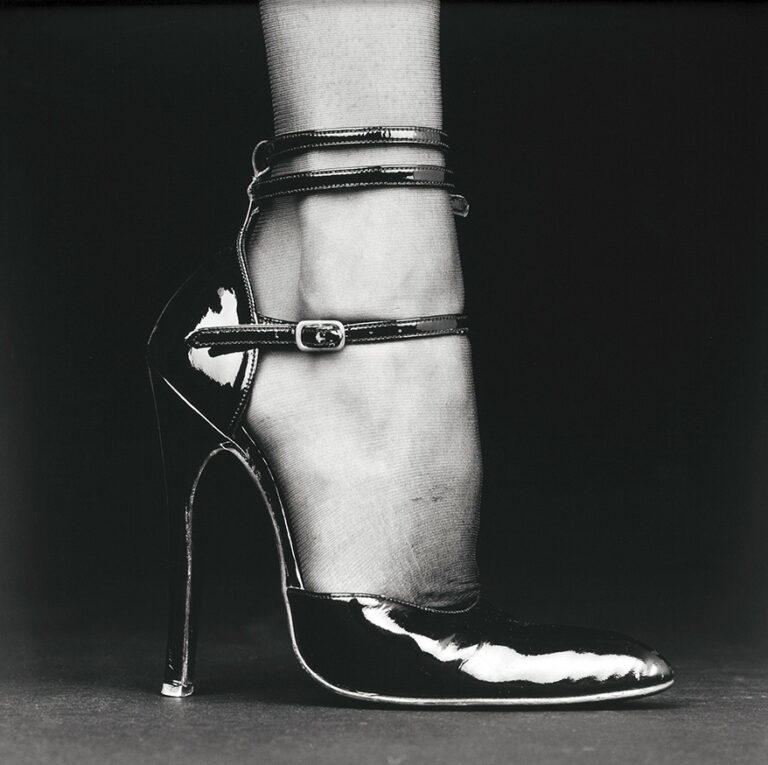 Robert Mapplethorpe Photography Art poster featuring a black and white close-up of a lower leg and foot in a patent leather high heel shoe with ankle straps.