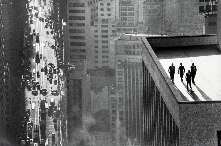 Rene Burri fine art photography poster featuring four men walking on a high-rise rooftop in a 1960s black and white São Paulo cityscape.