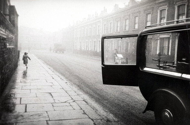 Robert Frank fine art photography poster featuring a solitary child running down a foggy, wet London street next to a vintage car with an open door.