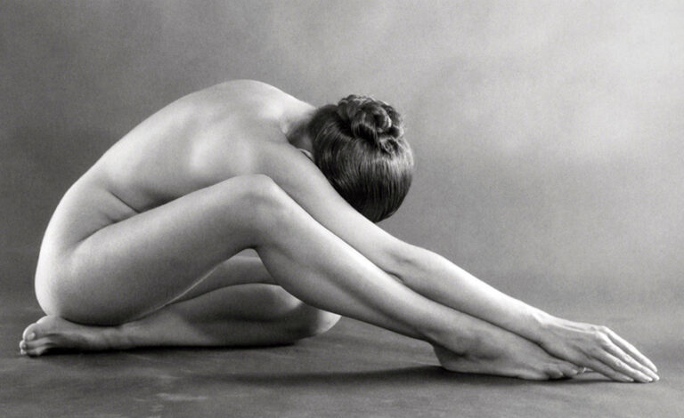 Ruth Bernhard Fine Art Photography poster featuring a classic black and white nude figure study of a curled, seated woman with smooth lines.