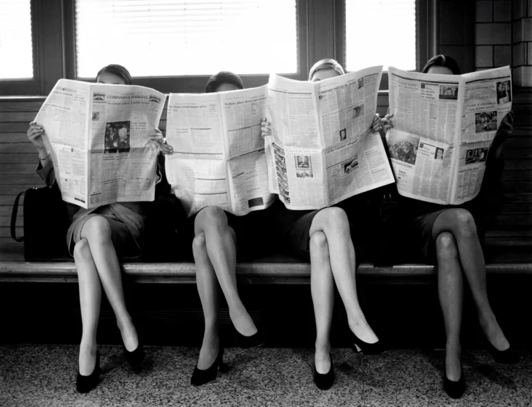 Black and white 'Women Reading Newspaper' vintage photography poster with four women on a bench.
