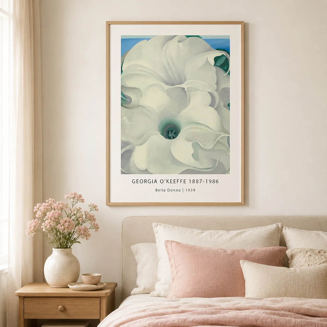 Room mockup of Bella Donna Print, Georgia O'Keeffe White Flower Wall Art Print, displayed as framed wall art in a bedroom setting as a portrait print with blue, teal, and green tones.