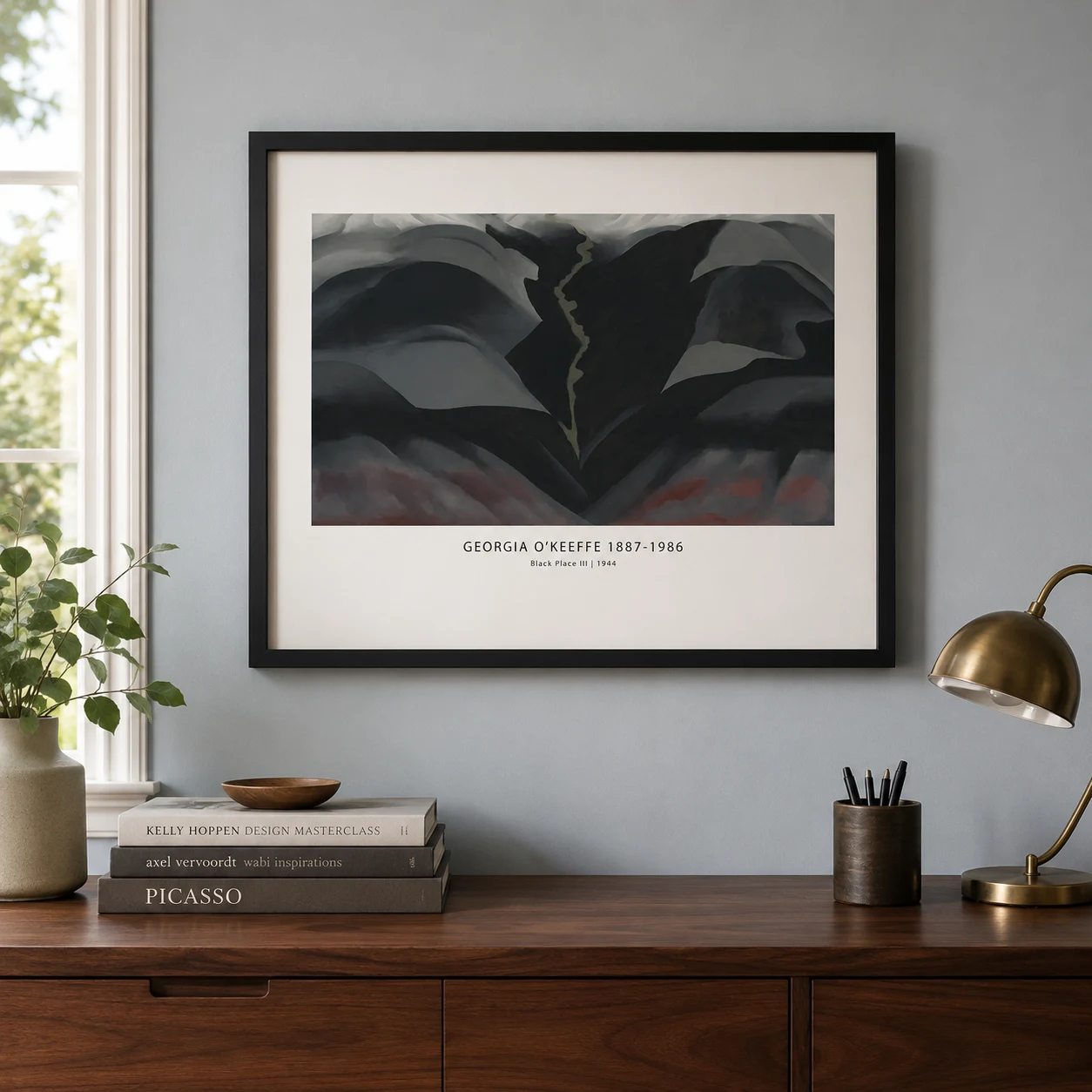 Room mockup of Black Place III Print, Georgia O'Keeffe Dark Desert Art, displayed as framed wall art in a living room setting as a landscape print with red, brown, and black tones.