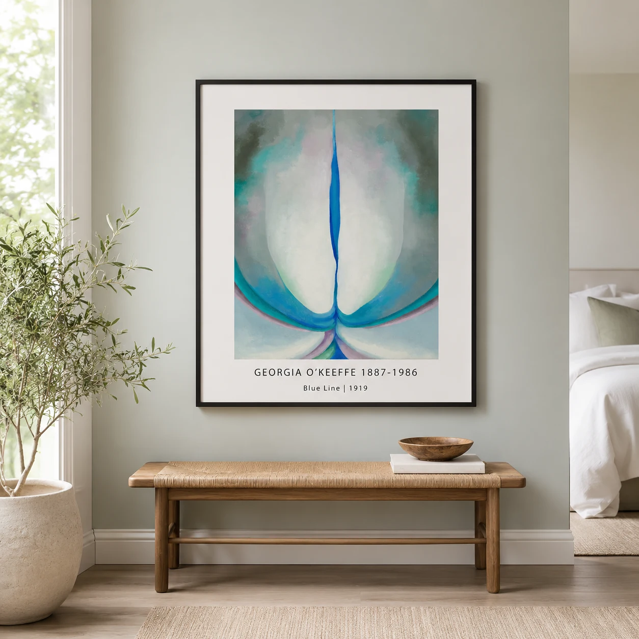 Room mockup of Blue Line Print, Georgia O'Keeffe Abstract Flower Wall Art Print, displayed as framed wall art in a bedroom setting as a portrait print with blue, green, and pink tones.