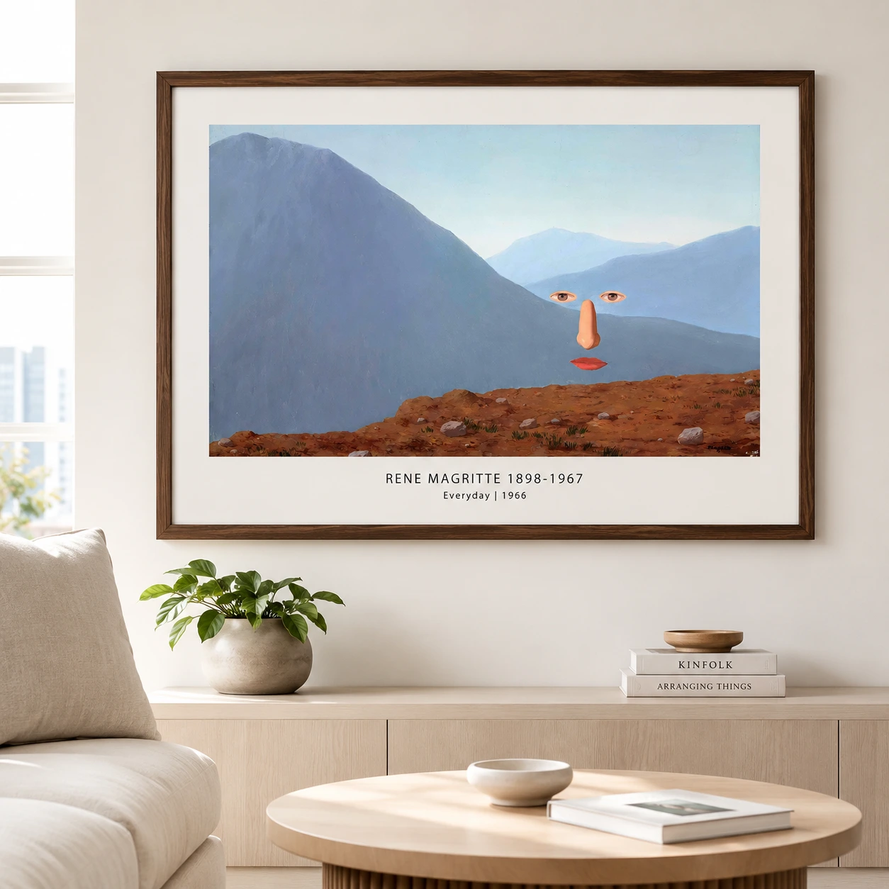 Room mockup of Everyday Print, Rene Magritte Floating Face Wall Art Print, displayed as framed wall art in a living room setting as a landscape print with blue and red tones.