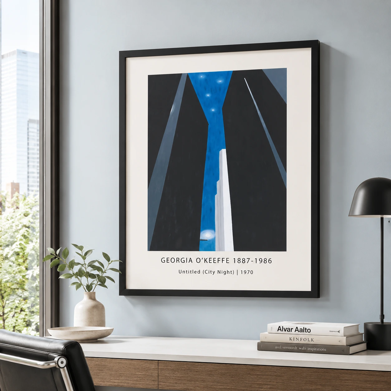 Room mockup of City Night Print, Georgia O'Keeffe Modern Architecture Art, displayed as framed wall art in a living room setting as a portrait print with black and white and blue tones.