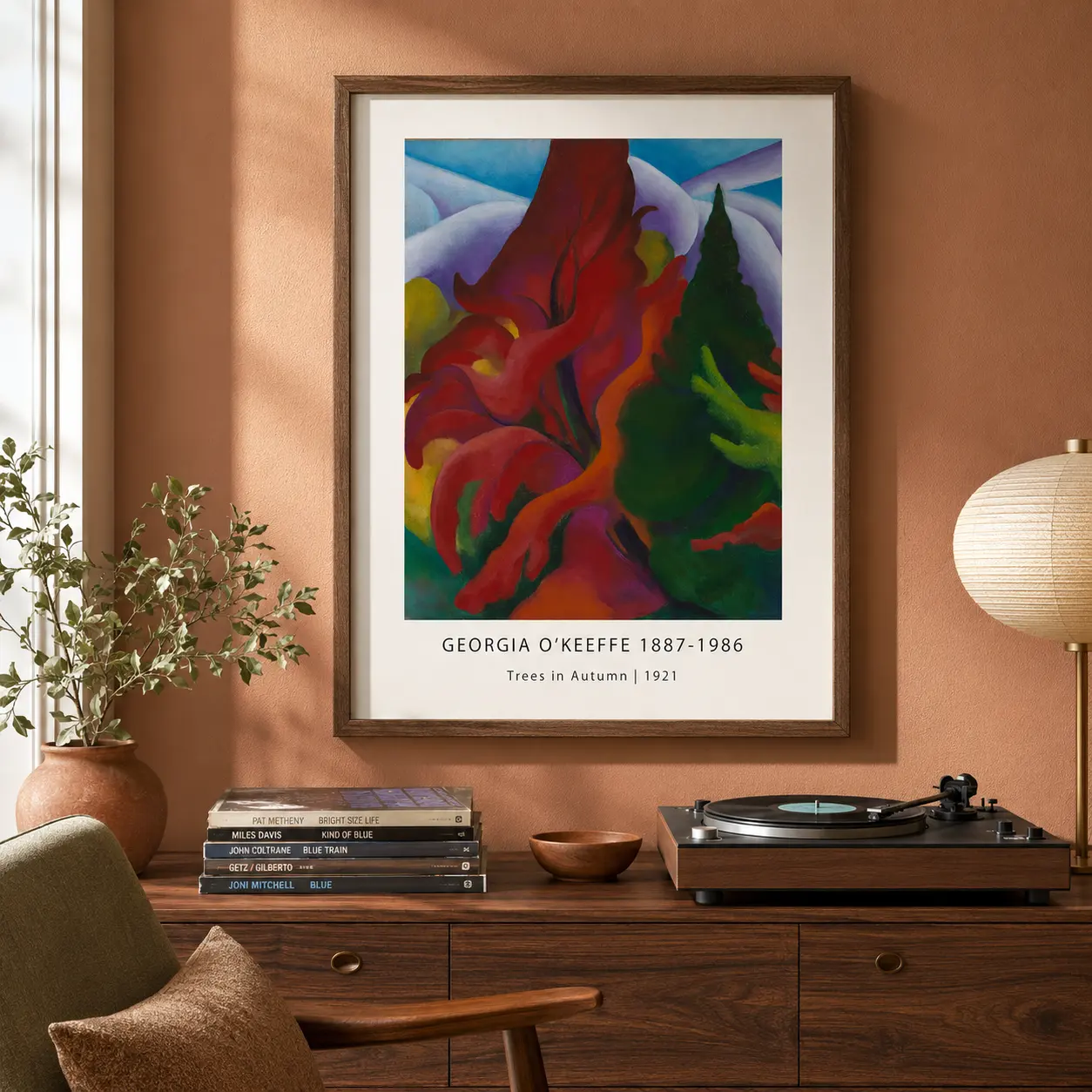 Room mockup of Trees in Autumn Print, Georgia O'Keeffe Fall Landscape Art, displayed as framed wall art in a living room setting as a portrait print with blue, green, and yellow tones.