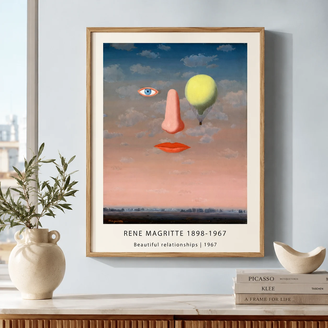 Room mockup of Magritte Relationships Print, Floating Face Surreal Wall Art Print, displayed as framed wall art in a living room setting as a portrait print with blue and pink tones.