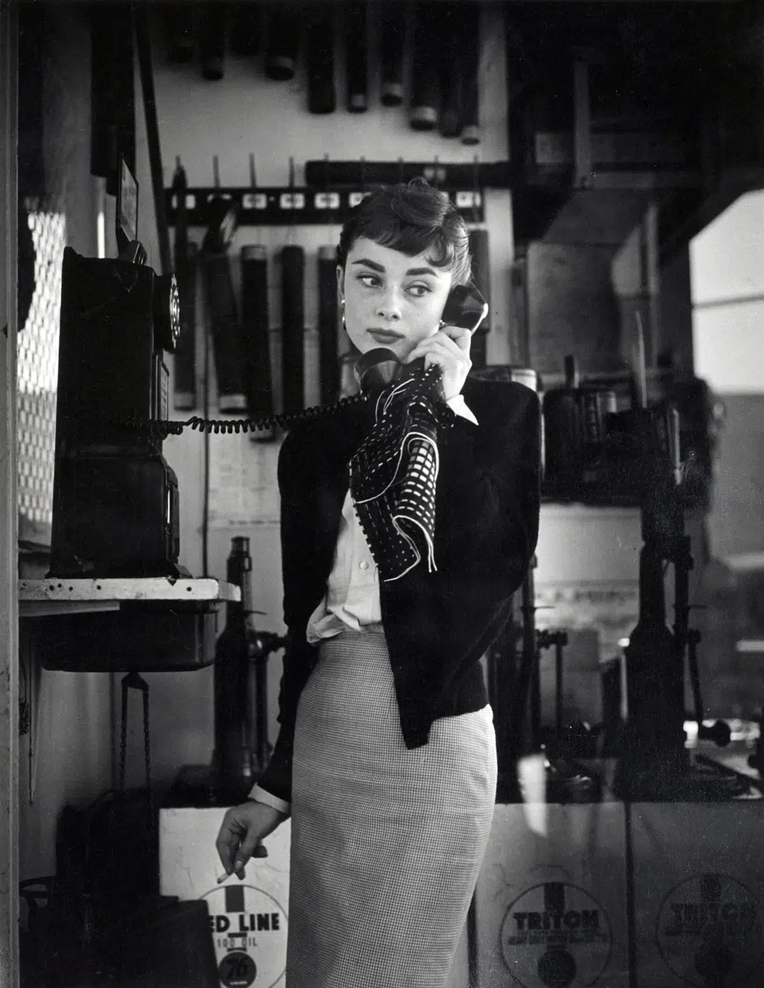 Audrey Hepburn Pay Phone Cigarette Photo print showing a vintage print of hepburn talking on a pay phone while holding a cig