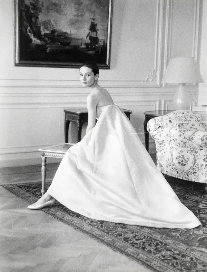 Audrey Hepburn wearing a voluminous Hubert de Givenchy white gown during a 1959 dress fitting in a vintage monochrome art print.