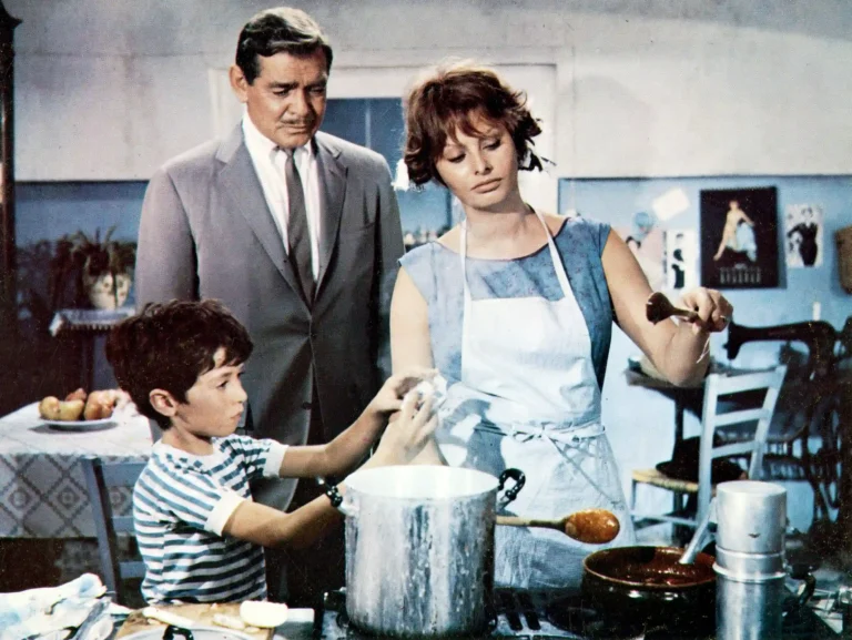 Clean artwork view of Clark Gable and Sophia Loren It Started In Naples 1960 Photography Print. Sophia Loren and Clark Gable share a kitchen scene with a young boy in this vibrant color still from the 1960 romantic comedy film It Started In Naples.