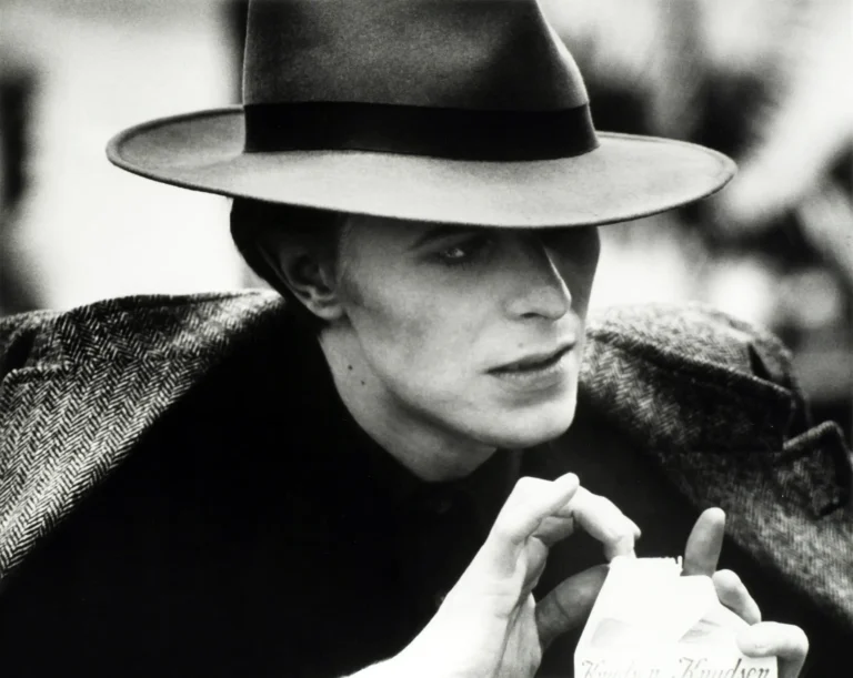 Clean artwork view of David Bowie The Man Who Fell To Earth Film Set Version 7 Alternate 2 Photography Print. A black and white silver gelatin photography print of David Bowie in a fedora and tweed coat on the 1975 film set of The Man Who Fell To Earth. MerchFuse.