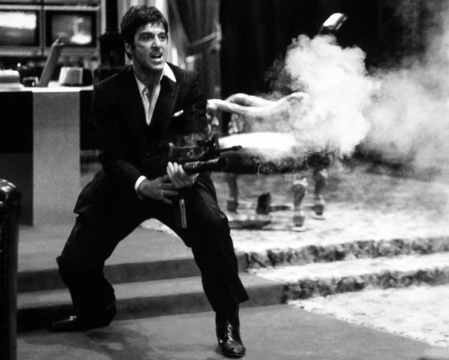 Al Pacino as Tony Montana in Scarface holding a rifle with smoke in black and white movie photography.