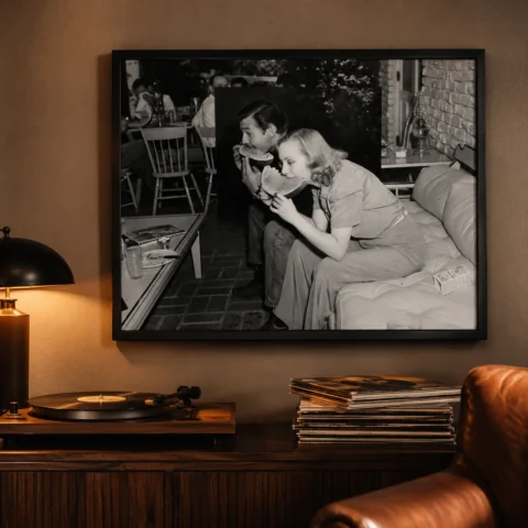 A framed vintage print of Clark Gable and Carole Lombard eating watermelon hanging in a sophisticated home office.