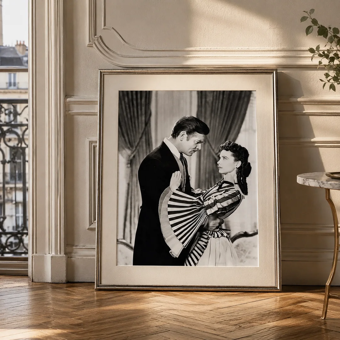 Room mockup of Clark Gable and Vivien Leigh Gone with the Wind Photography Print, displayed as framed wall art in a office setting as a portrait print with black and white and gold tones.