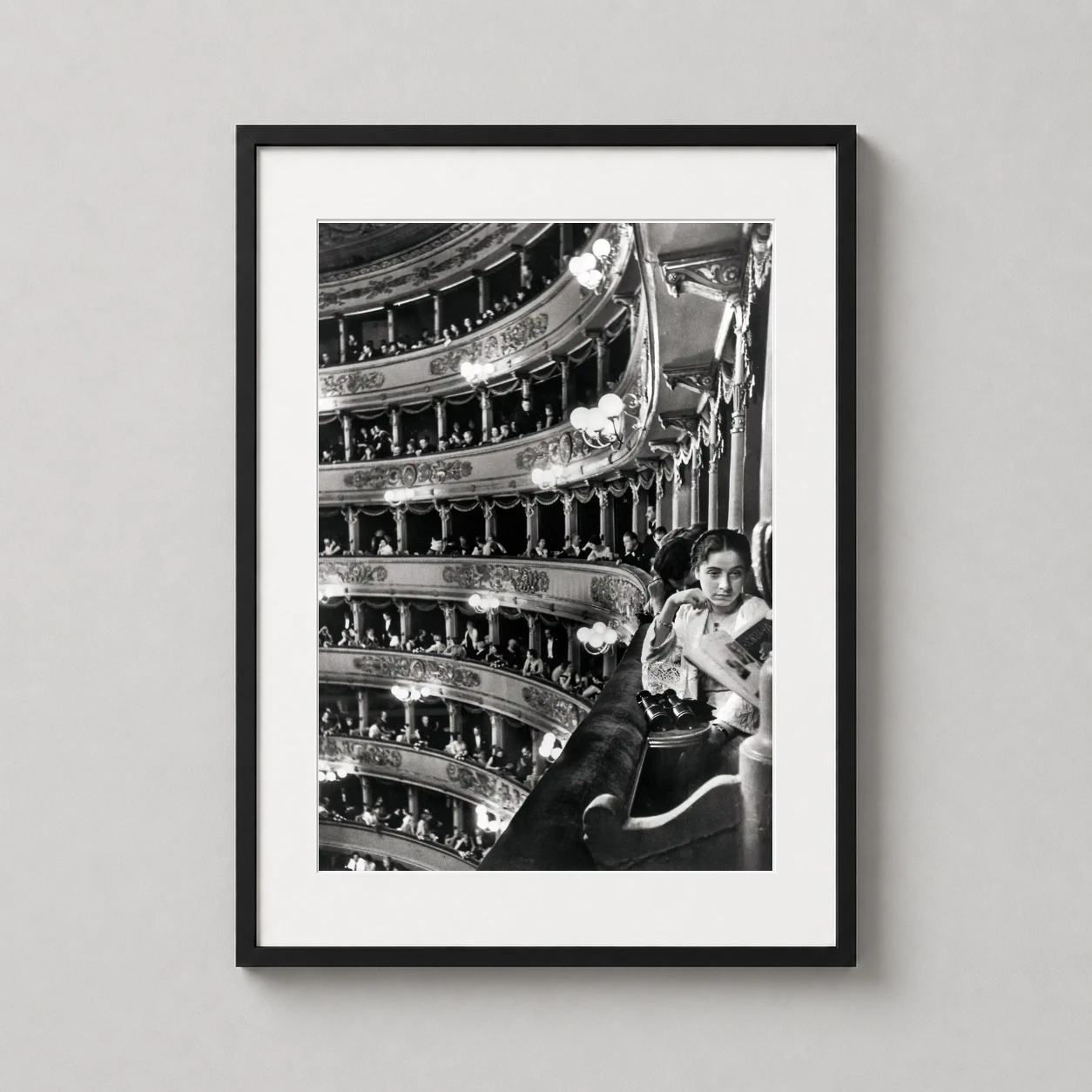 Room mockup of Alfred Eisenstaedt La Scala Milan 1933 Photography Print, displayed as framed wall art in a office setting as a portrait print with black and white and gold tones.