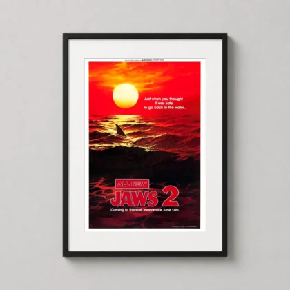 A framed Jaws 2 art print hanging on a neutral wall in a modern living room setting.