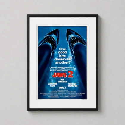 A framed Jaws 2 vintage movie poster featuring two sharks hanging on a neutral wall in a stylish modern gallery wall arrangement.