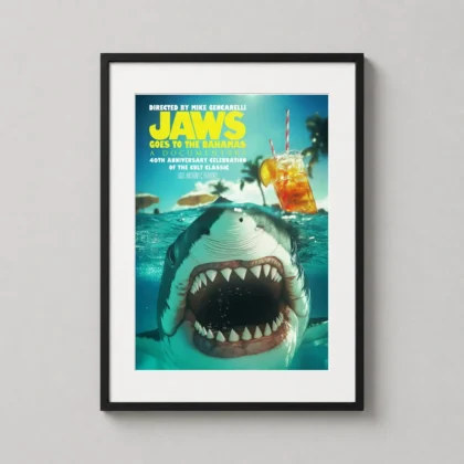 A framed Jaws Goes to the Bahamas art print hanging in a bright coastal living room, showcasing a shark and tropical drink.