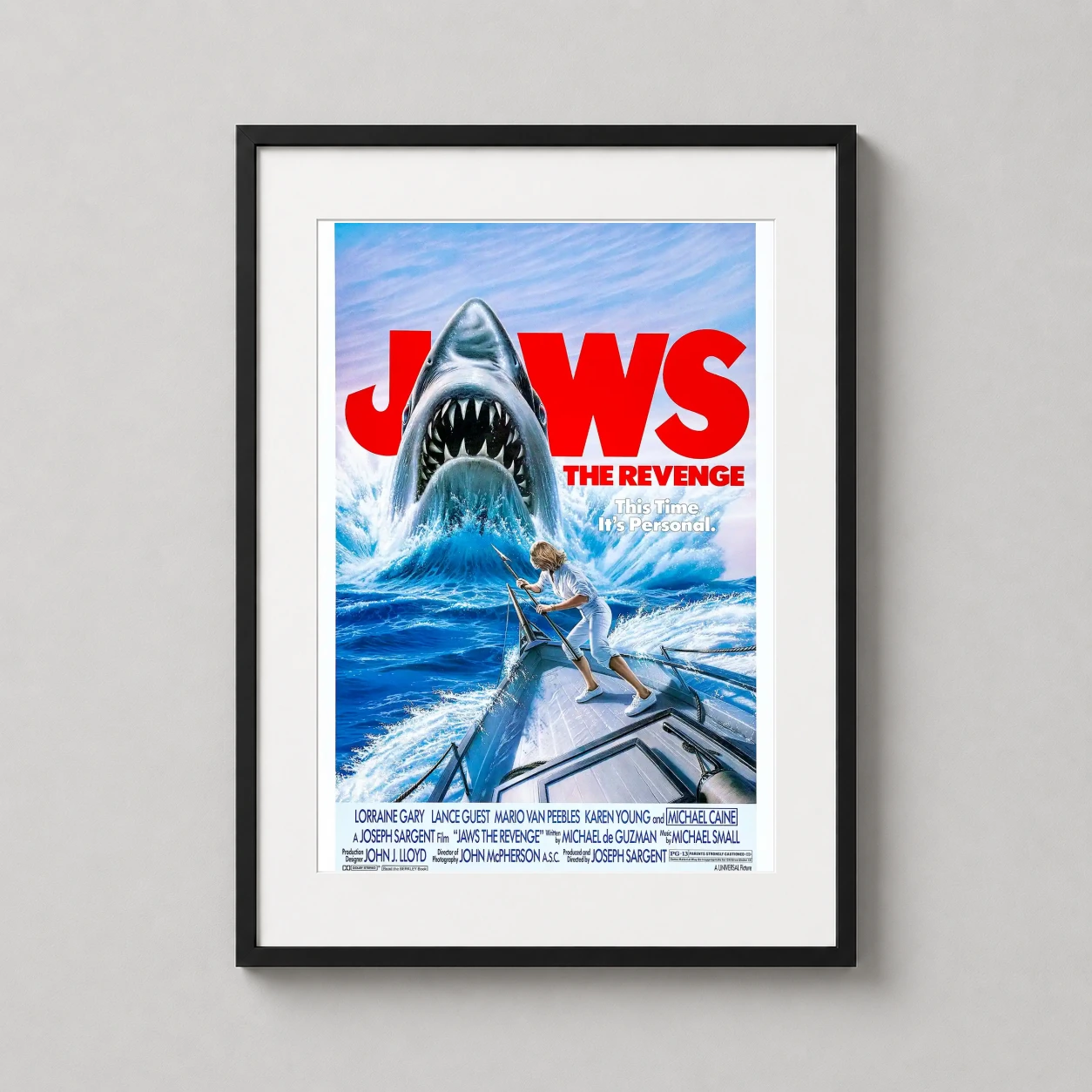 Room mockup of Jaws The Revenge 1987 Classic Shark Film Poster Movie Poster, displayed as framed wall art in a home theater setting as a portrait print with blue, red, and white tones.