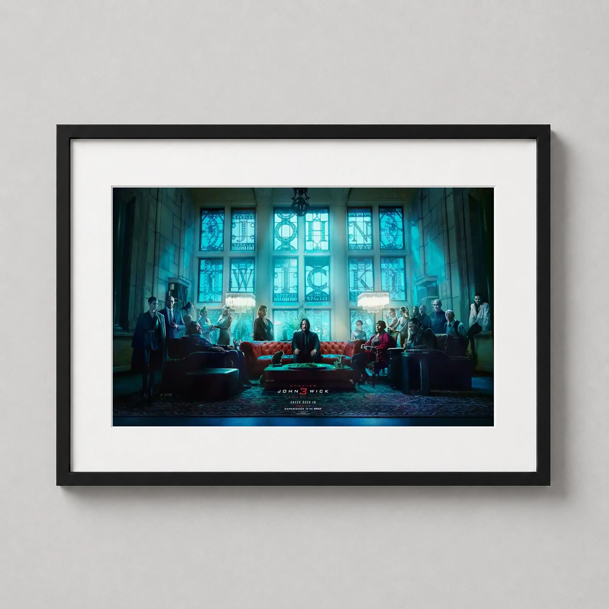 John Wick Chapter 3 — john Wick sits on a red leather sofa beneath glowing blue stained-glass