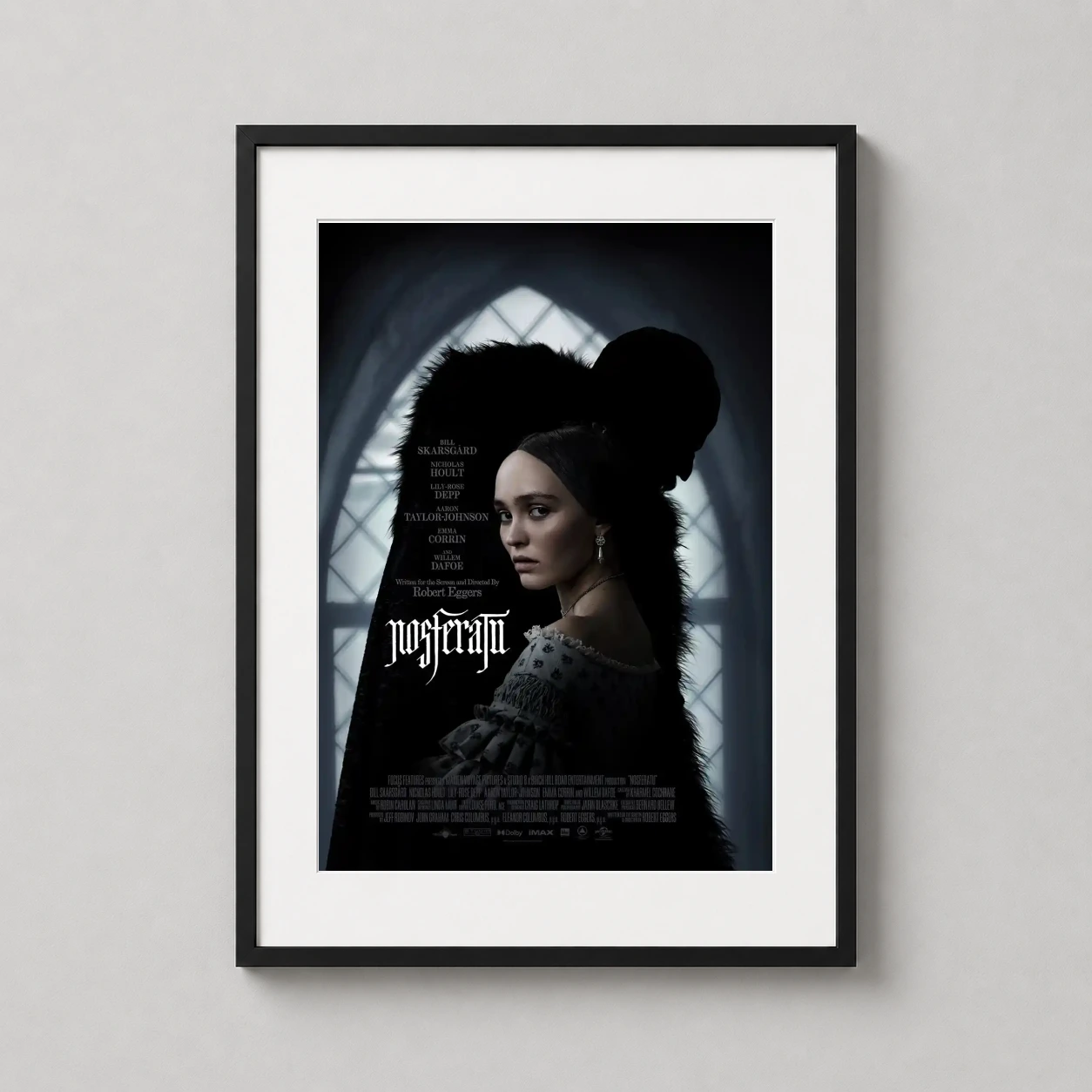Room mockup of Nosferatu 2024 Gothic Lily, Rose Depp Movie Poster, displayed as framed wall art in a home theater setting as a portrait print with pink tones.