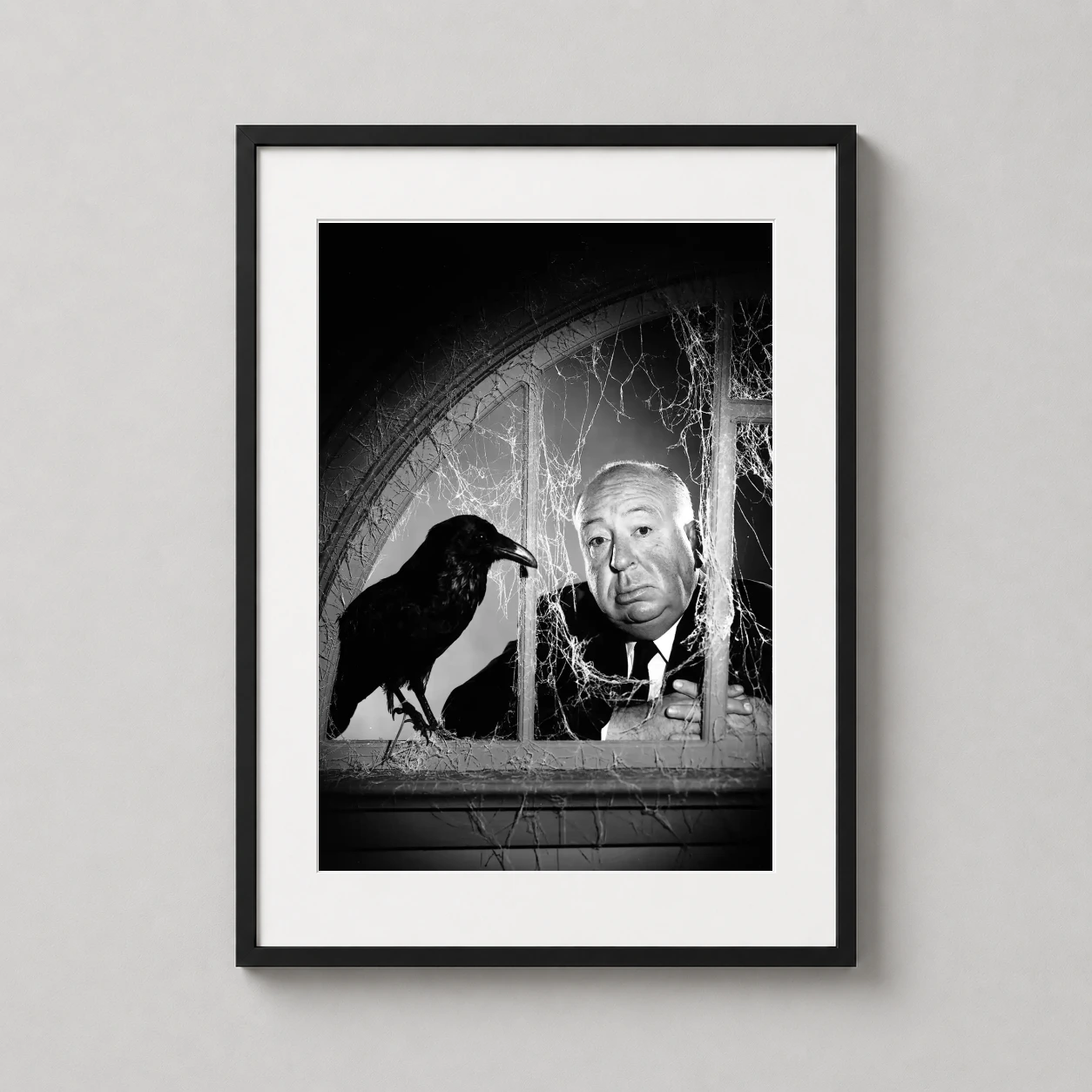 Alfred Hitchcock — black and white photograph of Alfred Hitchcock peering through a