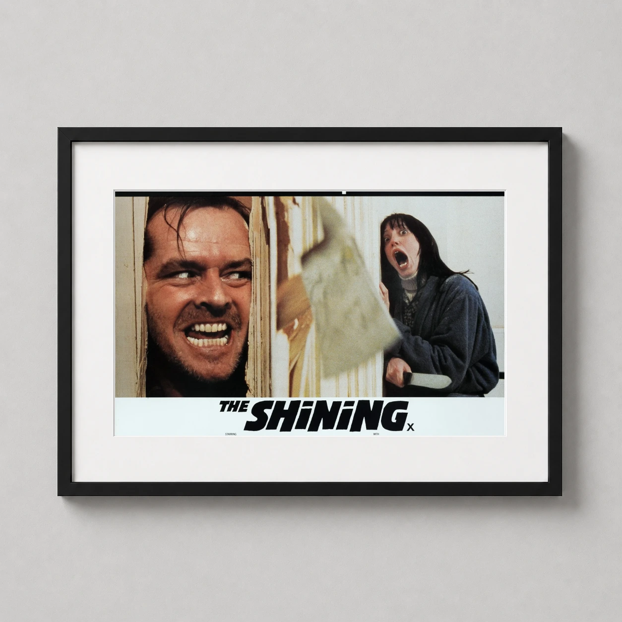 Room mockup of The Shining Here's Johnny Scene Vintage Horror Movie Poster, displayed as framed wall art in a home theater setting as a landscape print.