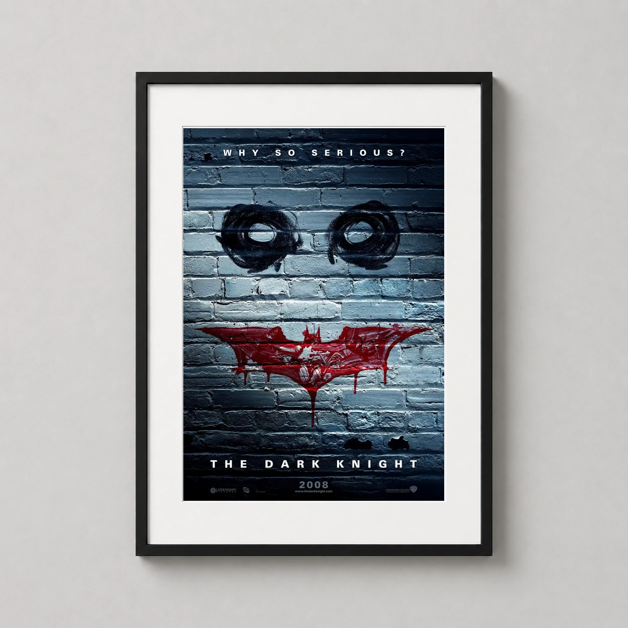 Room mockup of The Dark Knight Why So Serious Graffiti Brick Movie Poster, displayed as framed wall art in a home theater setting as a portrait print with blue and red tones.