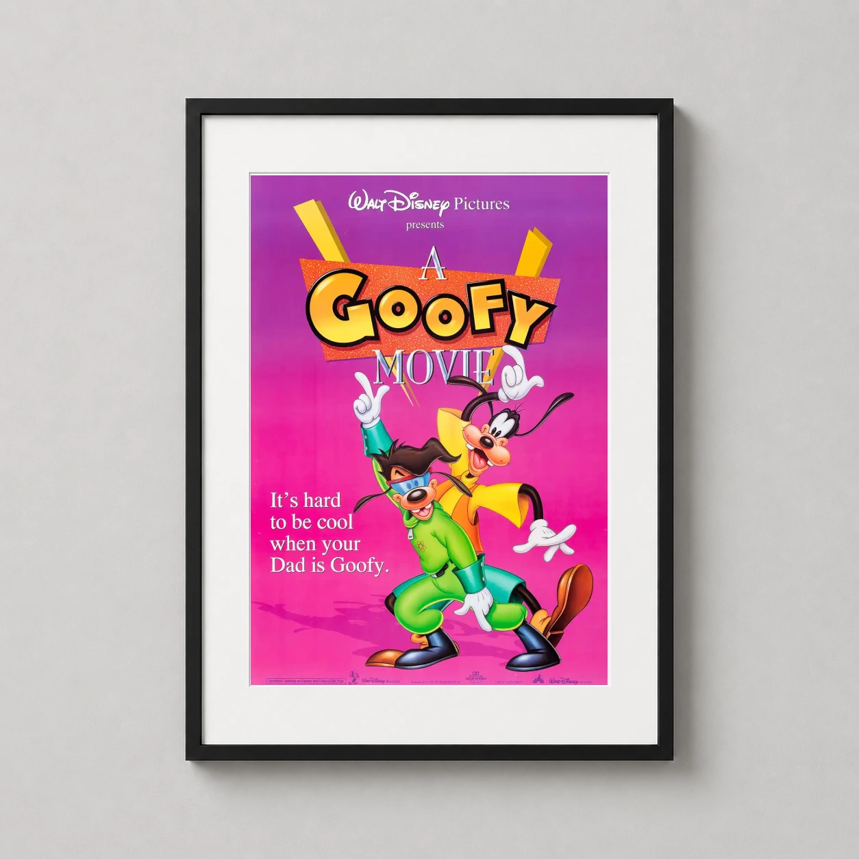 Room mockup of A Goofy Movie Retro Disney Goofy and Max Movie Poster, displayed as framed wall art in a home theater setting as a portrait print with green, yellow, and pink tones.