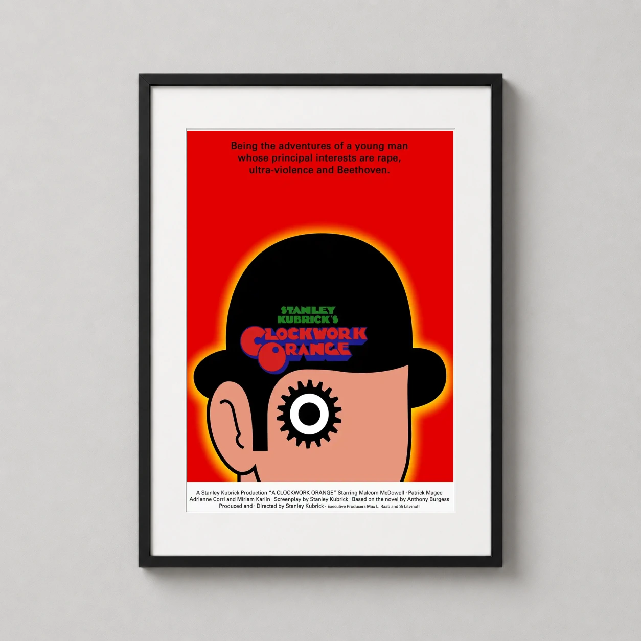 Room mockup of Clockwork Orange Movie Minimalist Eye Red Poster, displayed as framed wall art in a home theater setting as a portrait print with red tones.