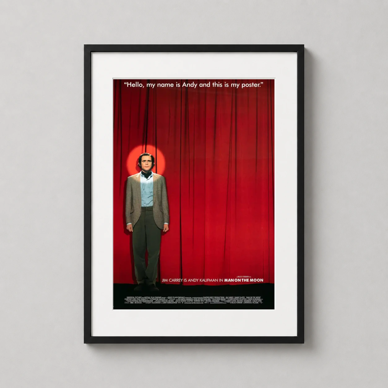 Room mockup of Man on the Moon Andy Kaufman Red Curtain Movie Poster, displayed as framed wall art in a home theater setting as a portrait print with red tones.