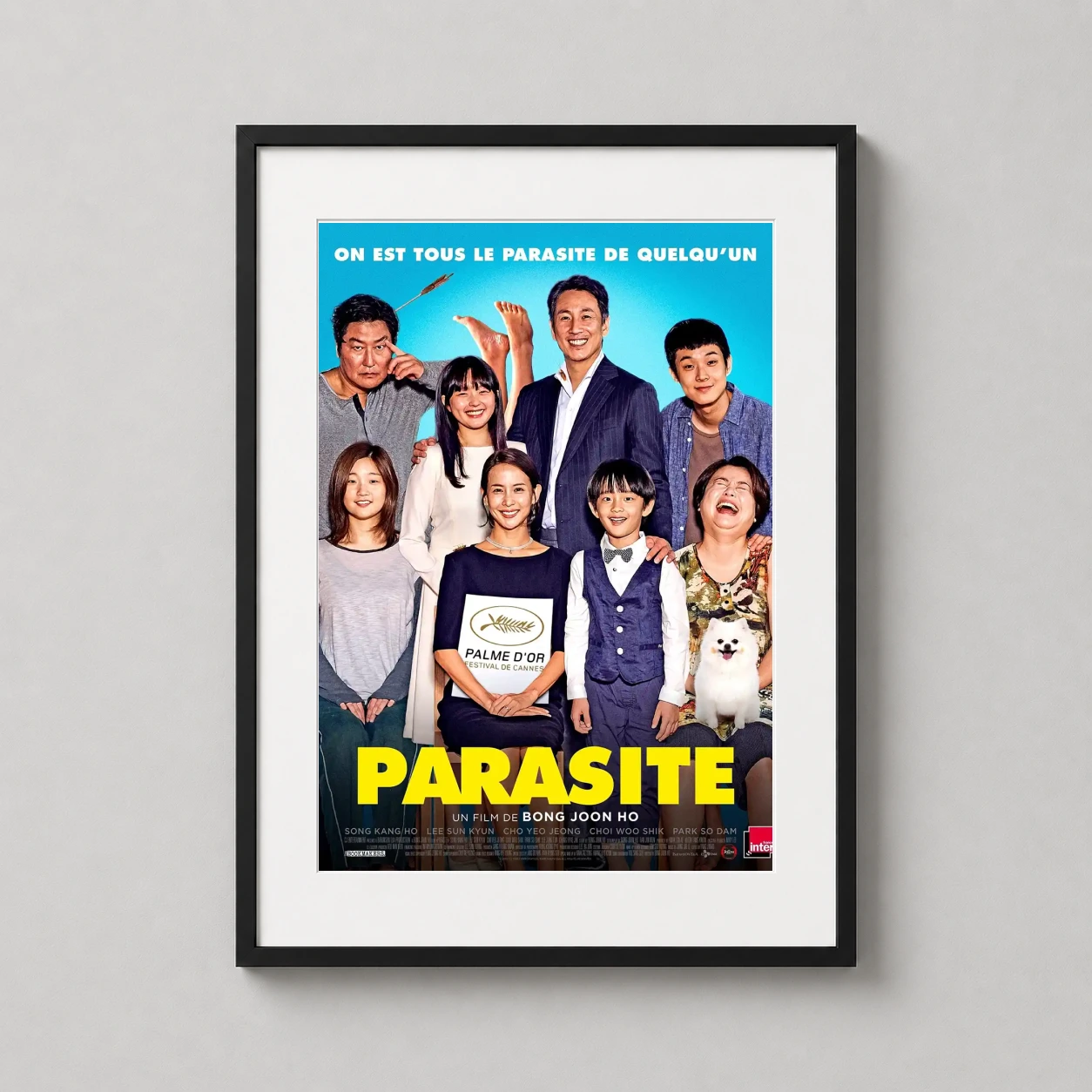 Room mockup of Parasite French Bong Joon-ho Film Poster, displayed as framed wall art in a home theater setting as a portrait print with blue and yellow tones.