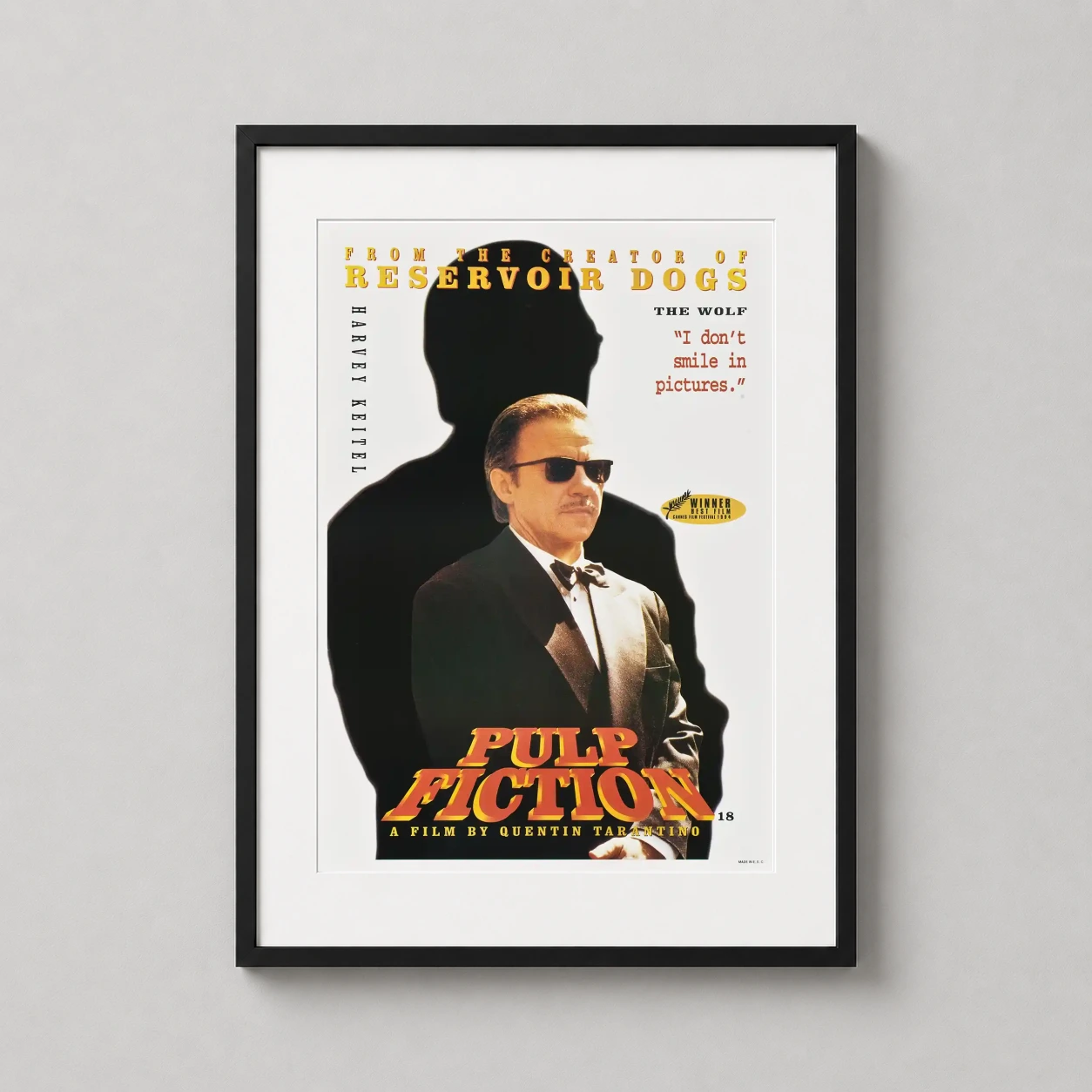 Room mockup of Winston Wolfe Pulp Fiction Harvey Keitel Movie Poster, displayed as framed wall art in a home theater setting as a portrait print with yellow tones.