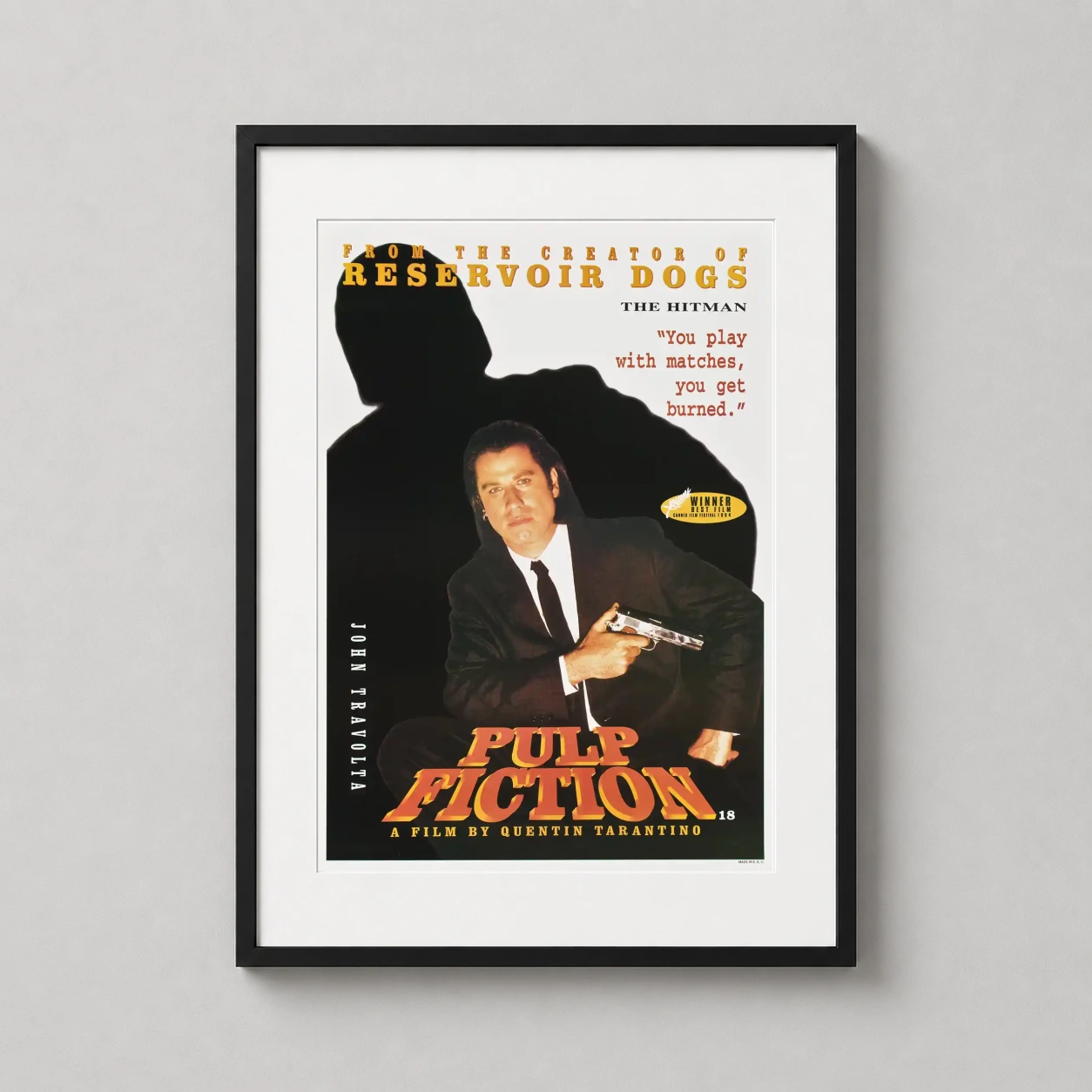 Room mockup of Pulp Fiction Vincent Vega John Travolta Movie Poster, displayed as framed wall art in a home theater setting as a portrait print with yellow, red, and black tones.