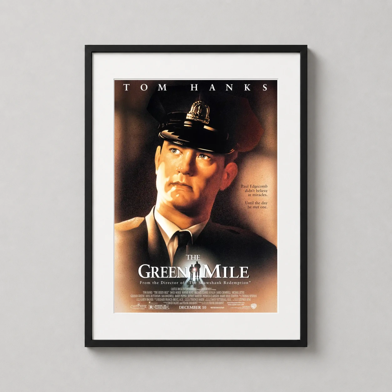 Room mockup of The Green Mile, Paul Edgecomb Tom Hanks Movie Poster, displayed as framed wall art in a home theater setting as a portrait print with green tones.