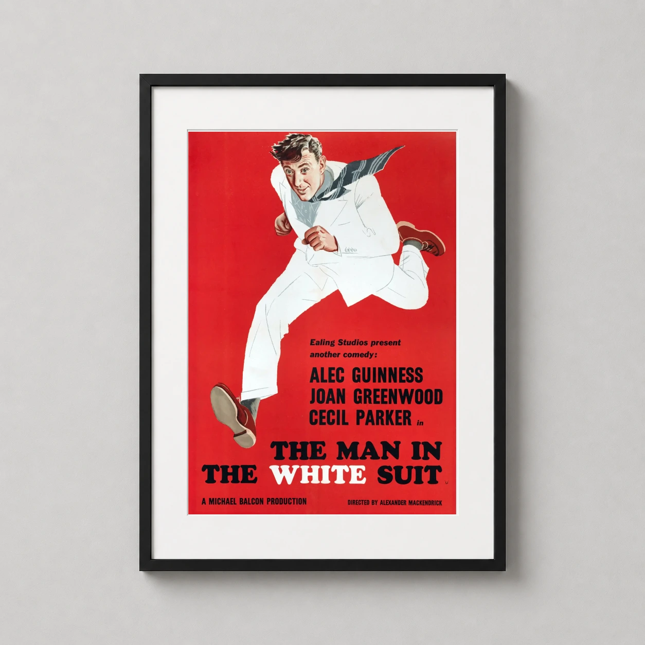 Man the Suit Alec Guinness — alec Guinness leaps across a vibrant red background in this vintage