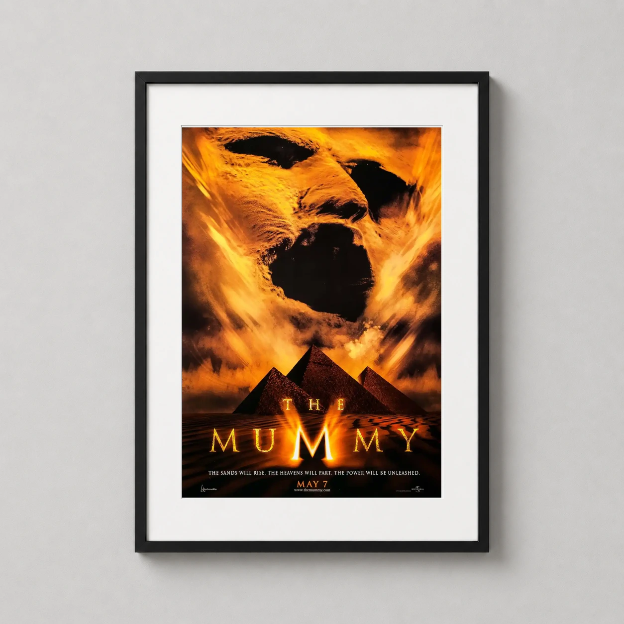 Room mockup of The Mummy 1999 Imhotep Sandstorm Movie Poster, displayed as framed wall art in a home theater setting as a portrait print with gold and orange tones.
