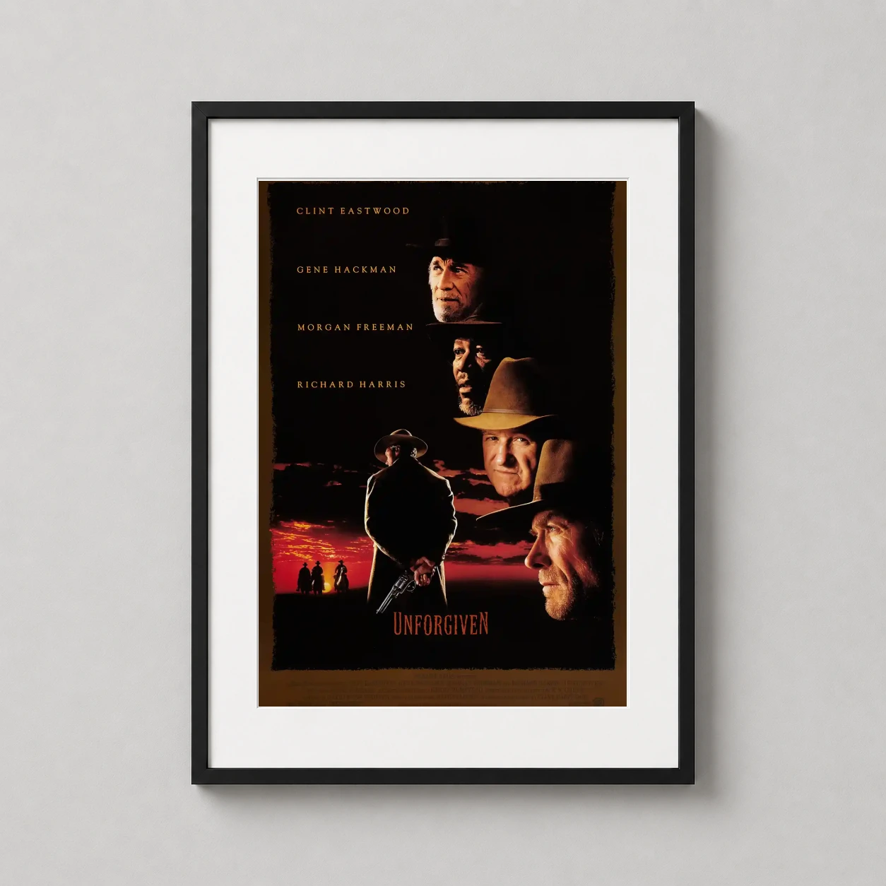 Room mockup of Unforgiven 1992 Clint Eastwood Western Movie Poster, displayed as framed wall art in a home theater setting as a portrait print with yellow and red tones.