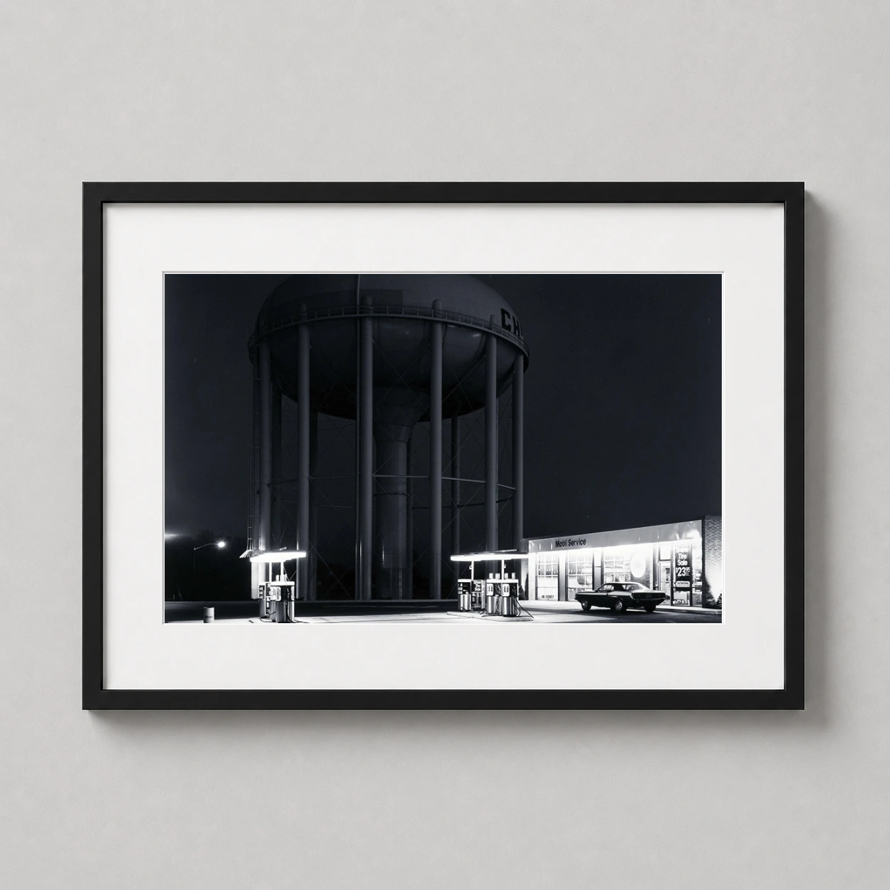 Room mockup of George Tice Petit's Mobil Station New Jersey Black and White Photography Print, displayed as framed wall art in a office setting as a landscape print with black and white tones.