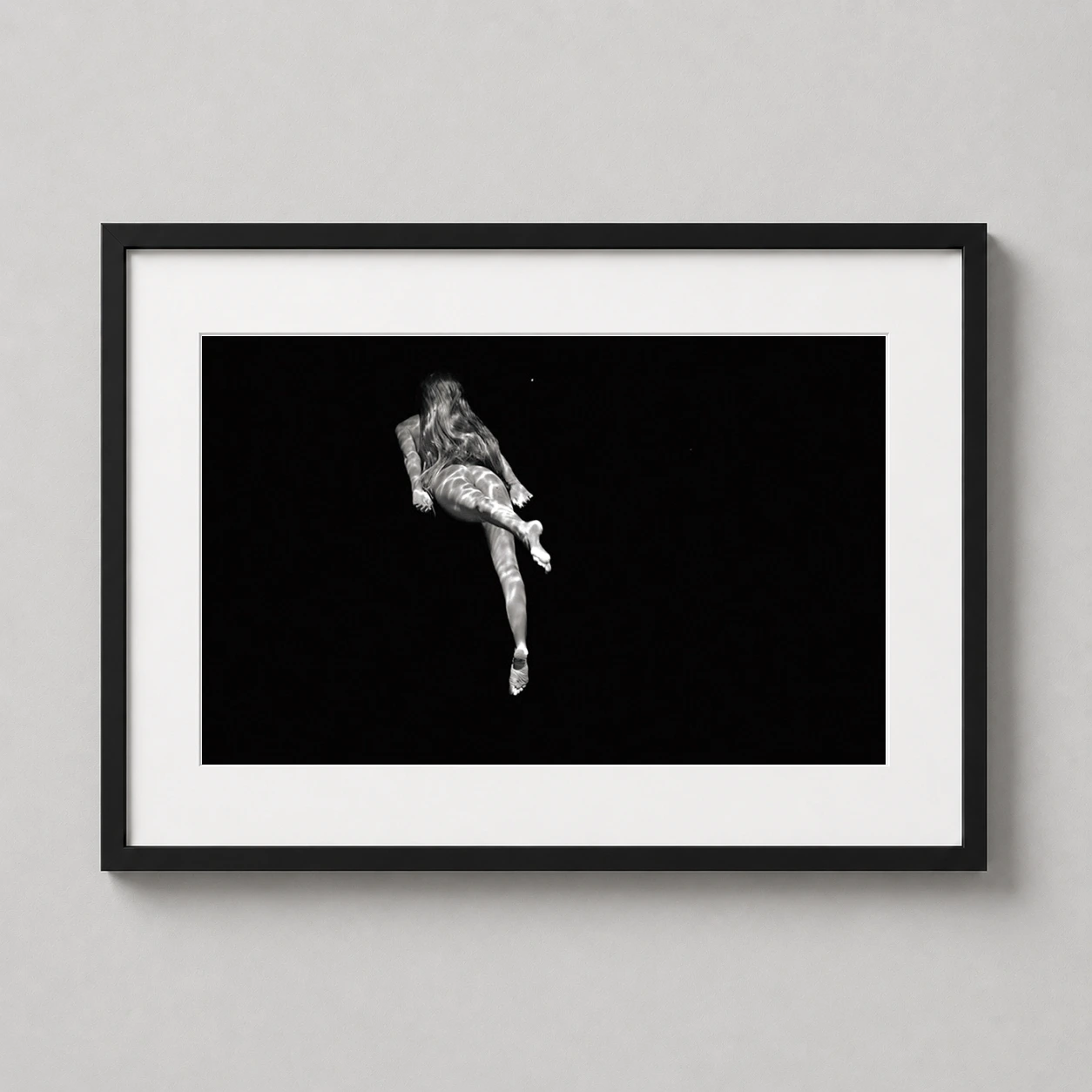 Michael Dweck Mermaid 18 — high-contrast black and white photograph of a woman swimming