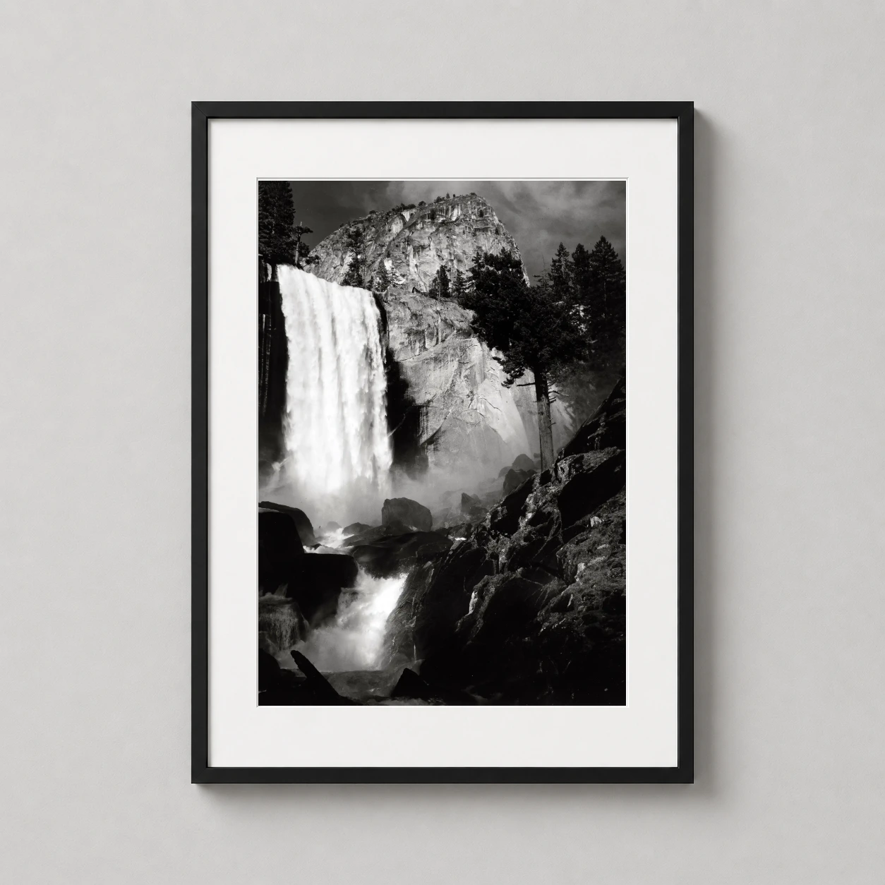 Room mockup of Ansel Adams Vernal Fall Yosemite Valley 1948 Photography Print, displayed as framed wall art in a office setting as a portrait print with black and white tones.